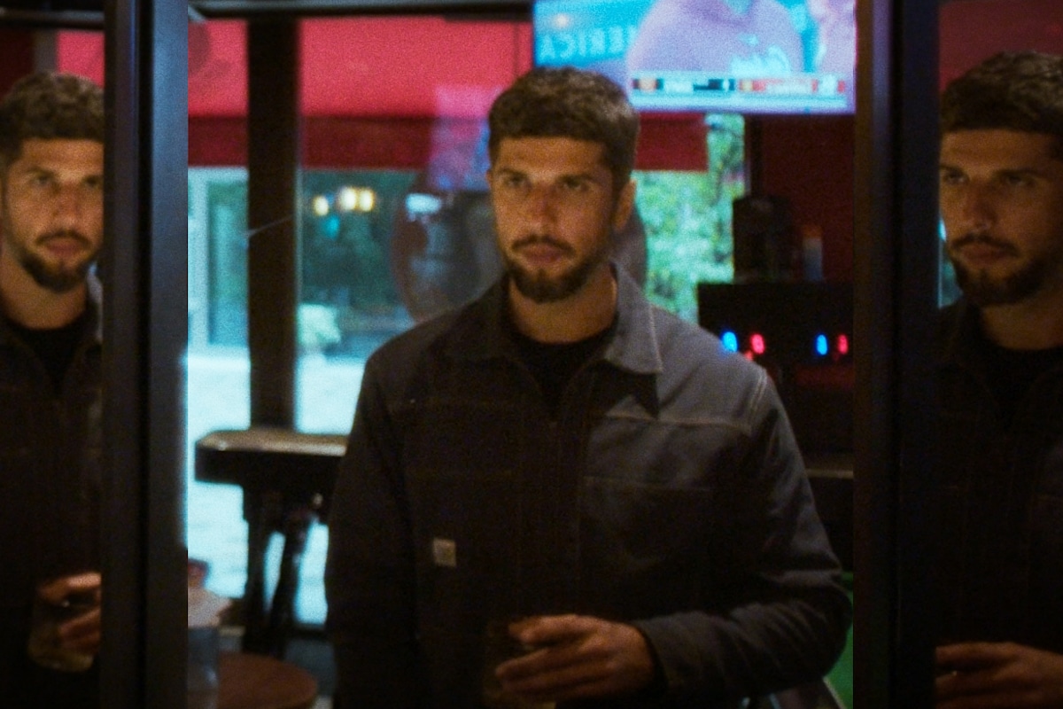 Poet Anthony Anaxagorou stands in a darkened bar